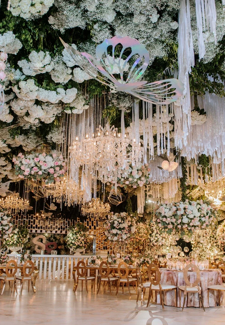 Celebración extraordinaria con arreglos florales y candelabros en el techo